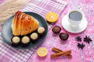 Free photo half-top view pastry slice with cinnamon and chocolate candies on pink background.