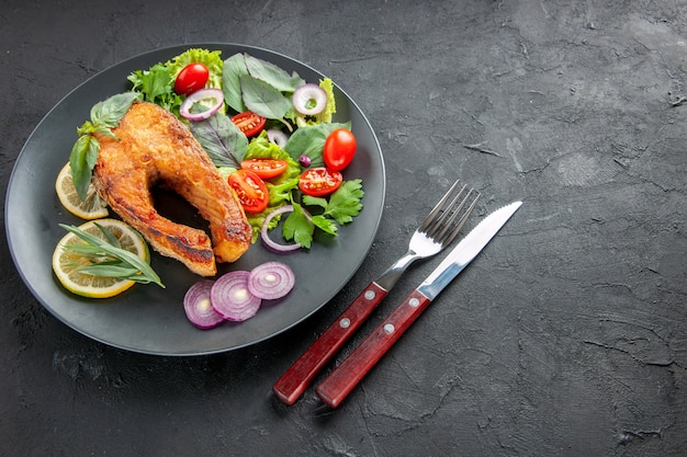 Half-top view tasty cooked fish with fresh vegetables and cutlery on a dark background food photo dish raw color meat seafood