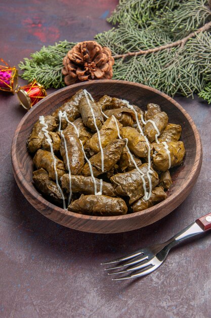 어두운 공간에 갈색 접시 안에 하프 탑보기 맛있는 잎 돌마 고기 요리