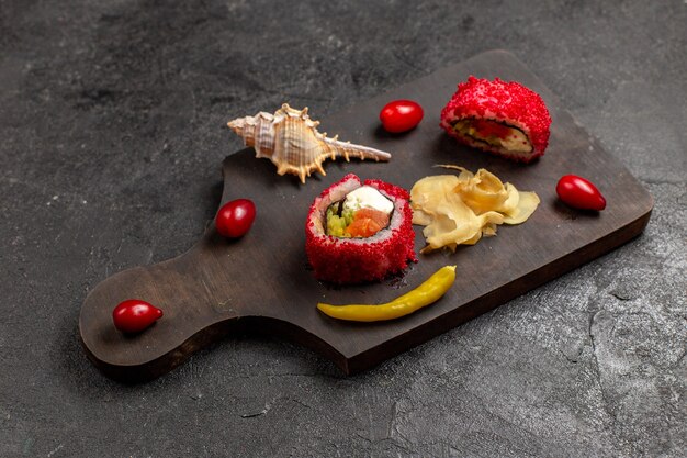 Half-top view of tasty sushi meal sliced fish rolls on dark grey wall