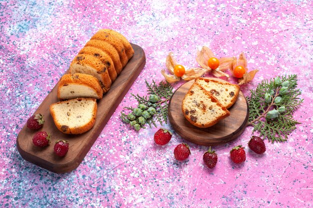 Half-top view 맛있는 케이크 달콤하고 맛있는 분홍색 바닥에 신선한 빨간 딸기와 슬라이스.