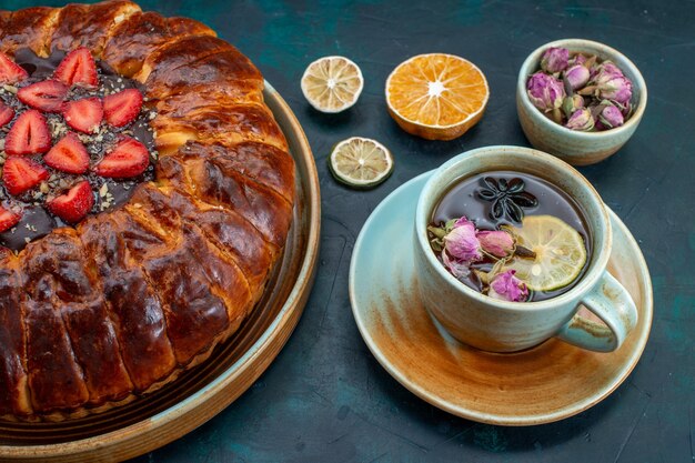 Half-top view of yummy strawberry pie baked delicious cake with cup of tea