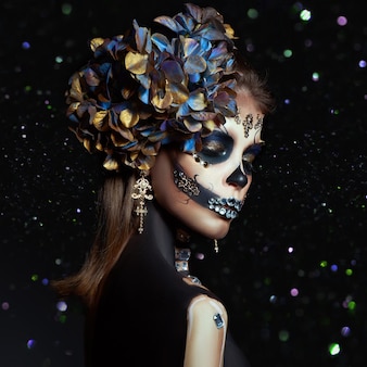 Halloween beauty portrait of a skeleton woman of death bokeh glitter, the makeup on the face. girl death halloween costume. day of the dead. charming and dangerous calavera catrina