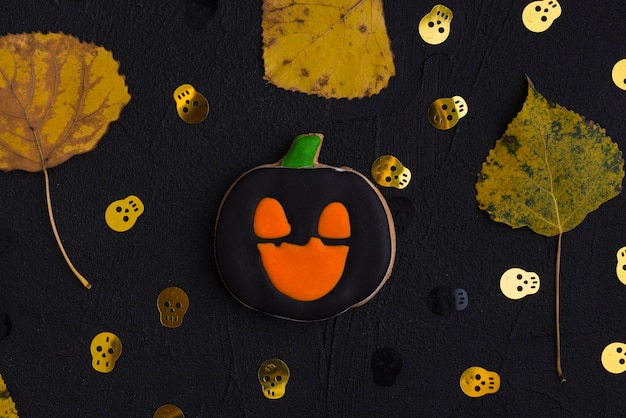 Halloween biscuit, dry leaves and ornamental skulls