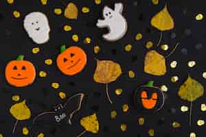 Foto gratuita biscotti di halloween e foglie secche tra i teschi ornamentali