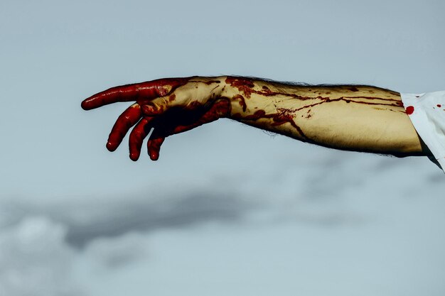 Halloween bloody hand on grey sky background