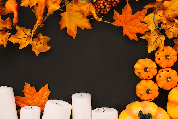 Foto gratuita composizione di halloween con candele e foglie