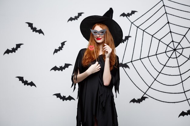 Halloween concept  beautiful girls in black witch dresses holding party props