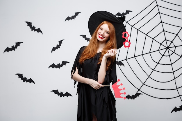 Halloween concept  beautiful girls in black witch dresses holding party props