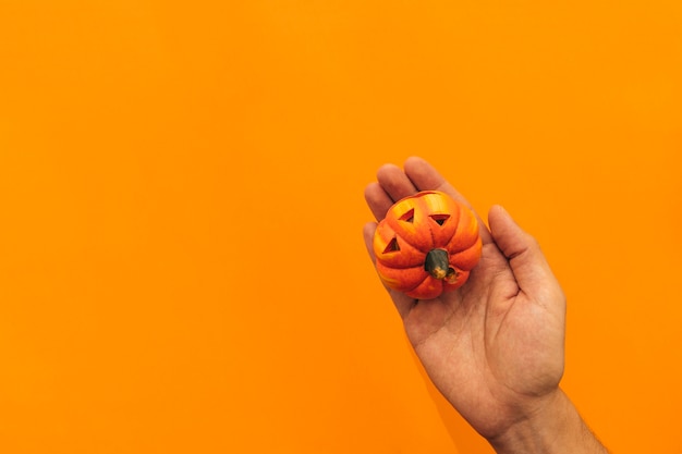 Halloween decoration with hand holding pumpkin