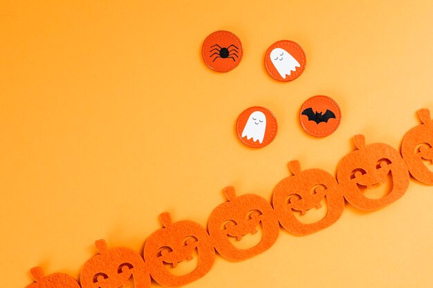 Halloween decoration with a pumpkin garland on an orange background