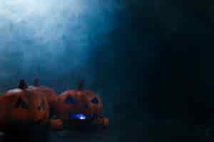 Free photo halloween decorative pumpkins with illumination inside and smoke