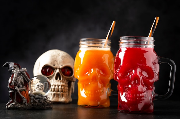 Напиток на хэллоуин тыквенный напиток и кровавый напиток в стакане с черепом Premium Фотографии