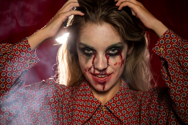 Foto gratuita modello femminile di halloween che fissa i suoi capelli