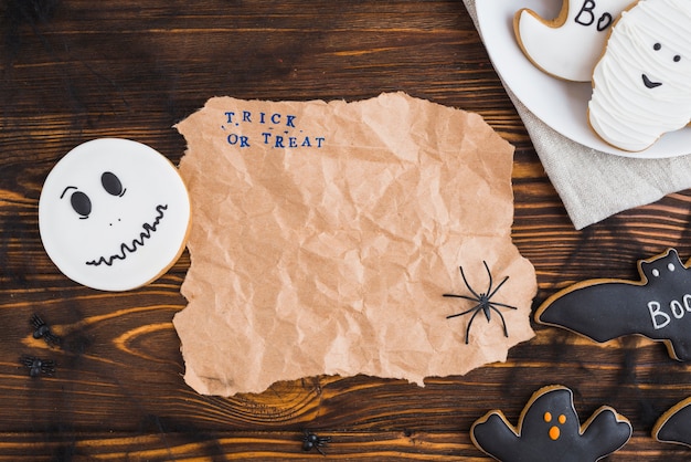 Бесплатное фото Пряники для хэллоуина, расположенные вокруг ремесленной бумаги