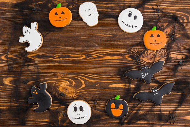 Halloween gingerbreads arranged in circle on wood background