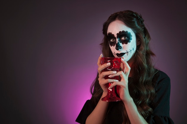 Halloween girl holding cup