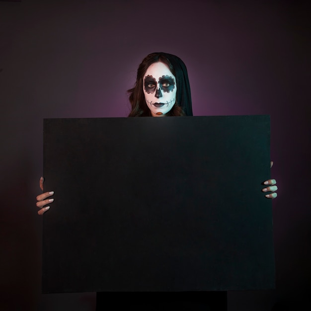 Halloween girl with makeup holding big board