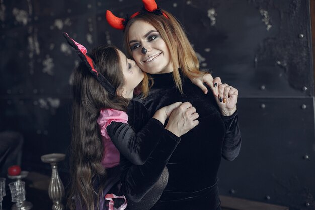 Хэллоуин. Мать и дочь в костюме хеллоуина. Семья дома.