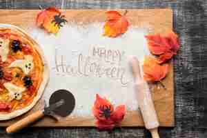 Бесплатное фото Хэллоуин пицца с листьями на деревянной доске
