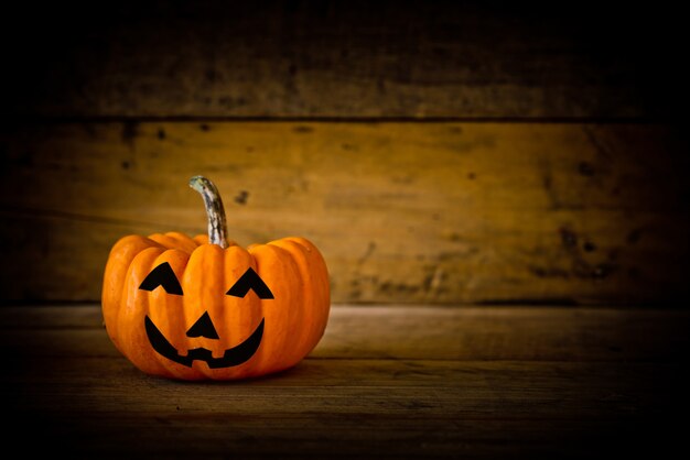 Halloween pumpkin head jack lantern on wooden background