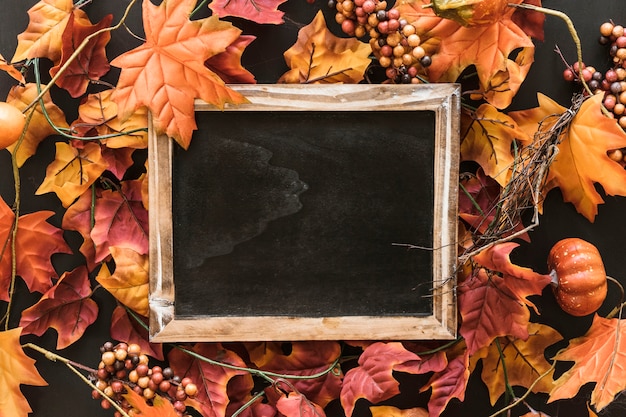 Composizione di ardesia di halloween su foglie di autunno