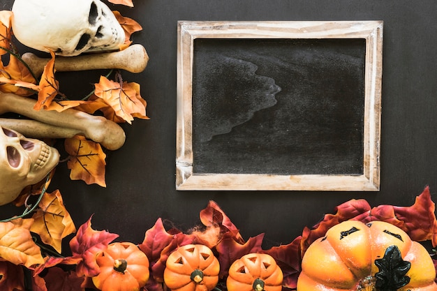 Halloween slate composition with autumn leaves and bones