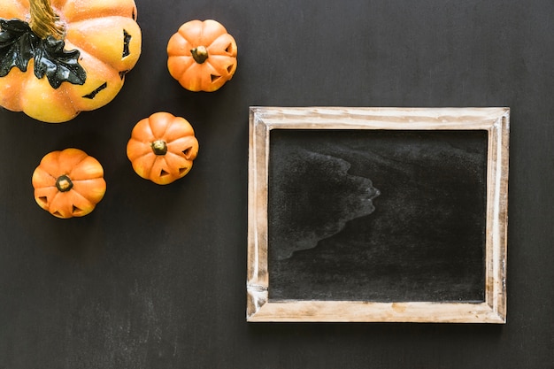 Foto gratuita composizione ardesia di halloween con zucche