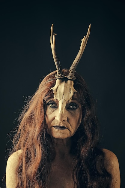 Halloween woman in black with long red hair and makeup.