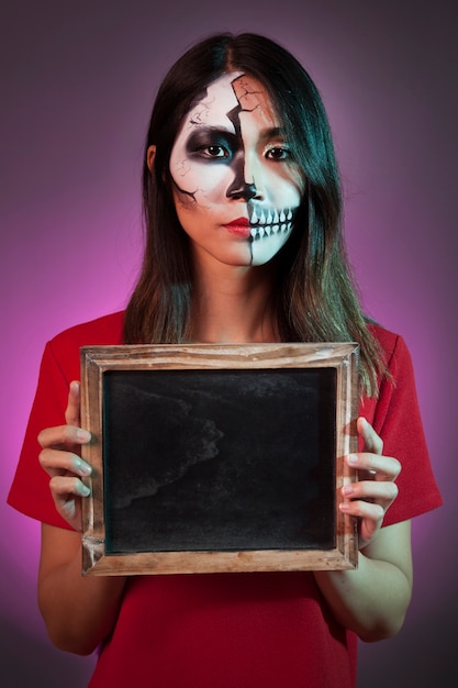 Free photo halloween woman holding slate