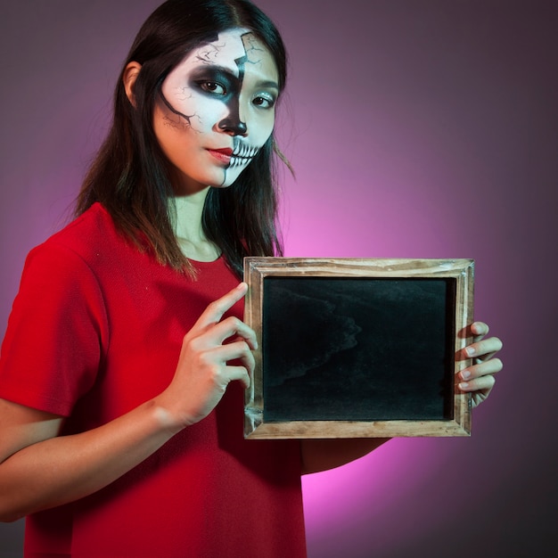 Free photo halloween woman presenting slate