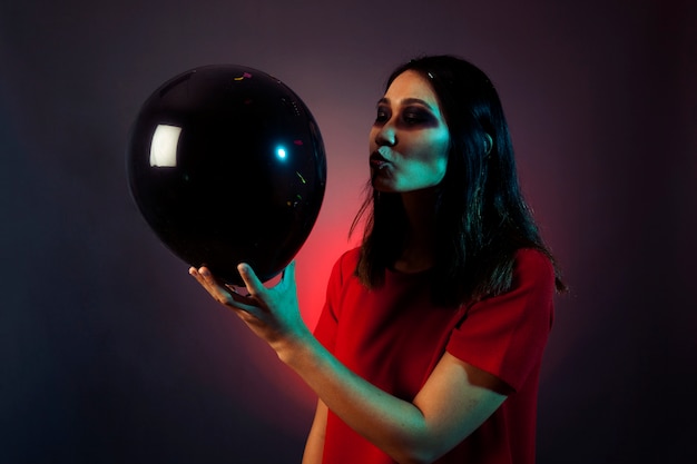 Halloween woman trying to kiss balloon