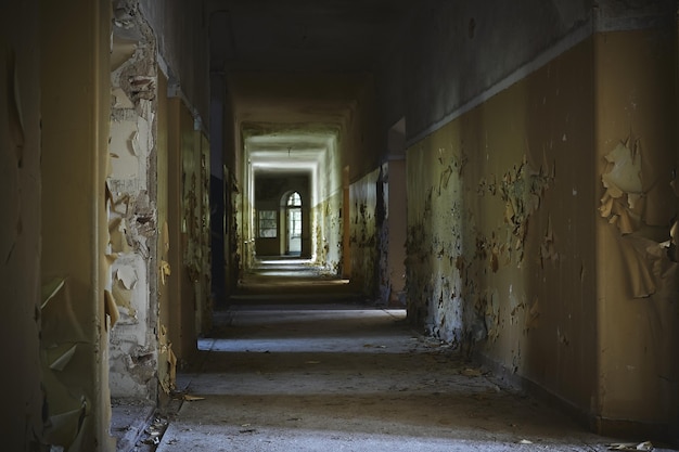 Hallway of an abandoned building with aged walls under the lights