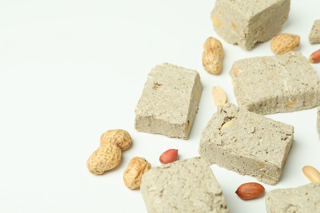 Halva with nuts on white background, space for text
