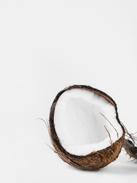 Halved coconut shell against white background