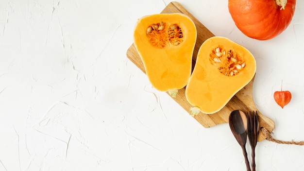 Free photo halved pumpkin on cutting board with copy space