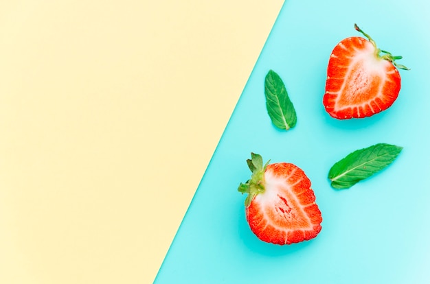 Halved tasty ripe strawberries and green leaves