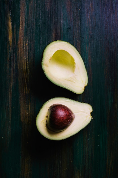 Halves of avocado on a cutting board top view