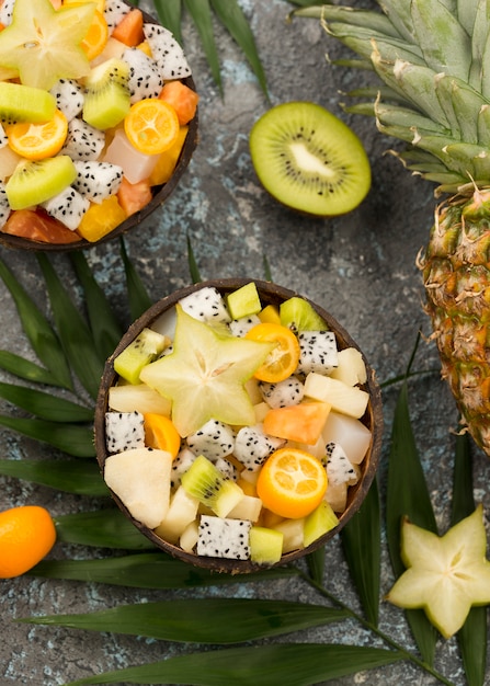 Halves of coconut filled with fruit salad flat lay