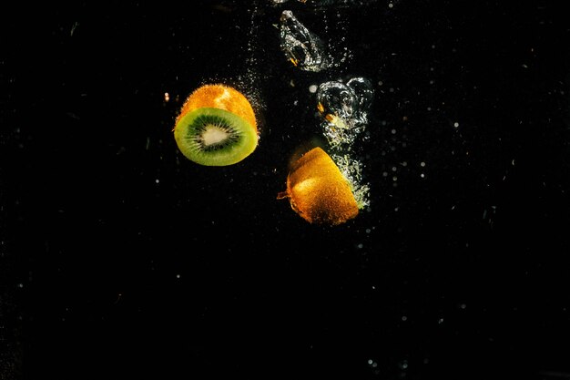 Halves of green kiwi fall in aquarium