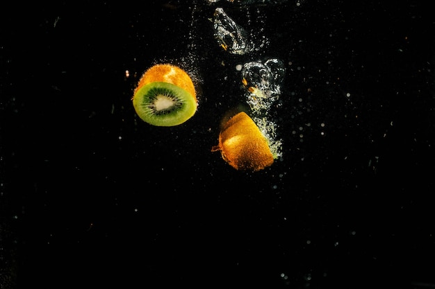 Halves of green kiwi fall in aquarium