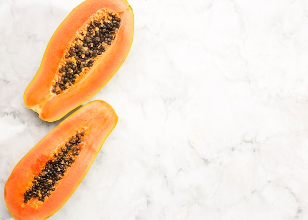 Halves of papaya fruit with copy space