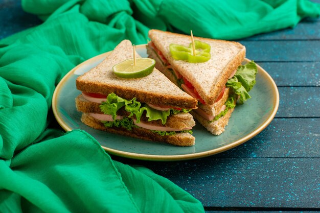 ham sandiwches inside green plateo on blue