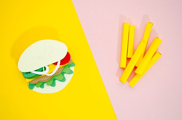 Реплики гамбургер и картофель фри на цветном фоне