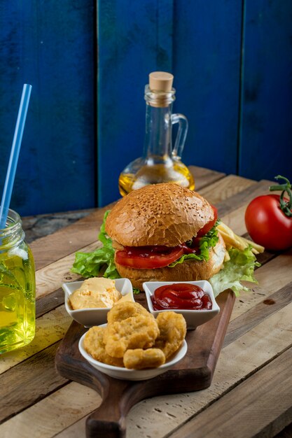 Hamburger,onion rolls and fried potatoes with sauces, olive oil and vegetables