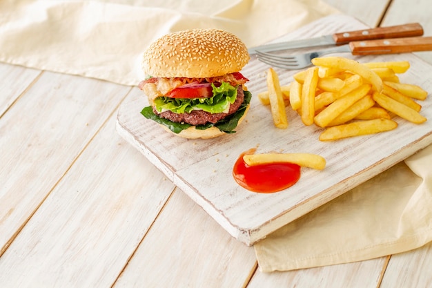 ハンバーガーとフライドポテトと木の板にソース