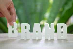 Free photo hand arrange white letters brand