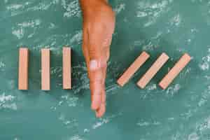 Free photo hand as barrier dividing wooden blocks.