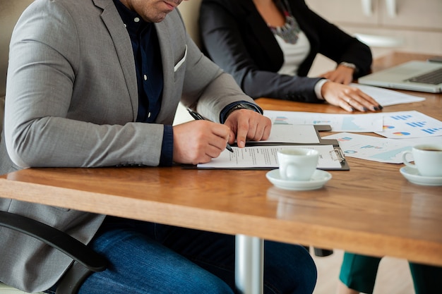 Free photo hand of businessman signing a contract in the meeting room. close up image