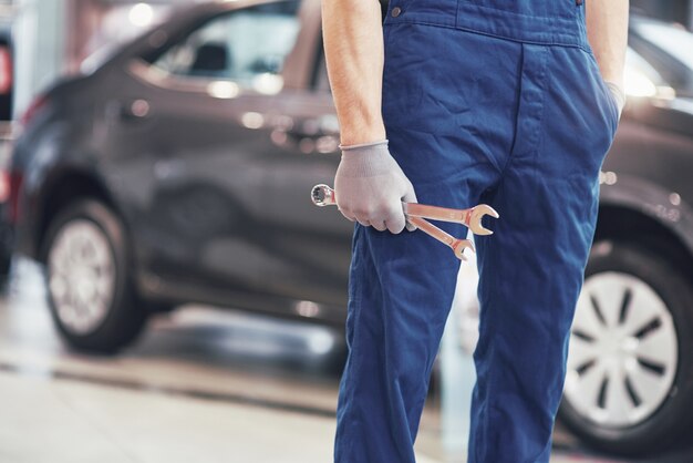 Hand of car mechanic with wrench. Auto repair garage